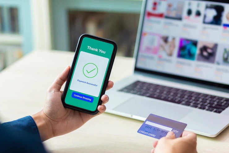 Customer completing a secure payment link on a phone while holding a bank card