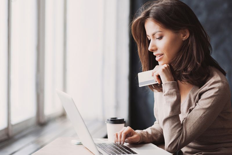 Small business operator taking a remote card payment at a laptop